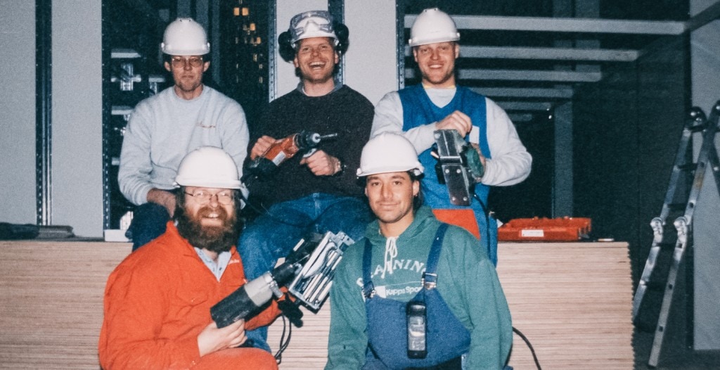 Fem menn fra 80-tallet med hjelm, verneutstyr og verktøy