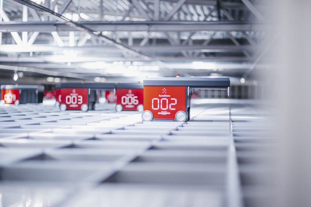 Røde AutoStore roboter plukker ordre på en grid.